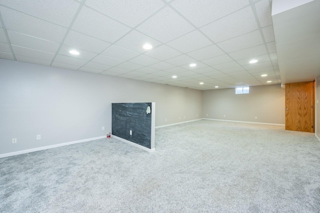 below grade area with carpet floors, baseboards, recessed lighting, and a paneled ceiling