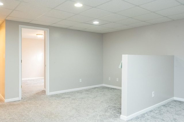 spare room with a paneled ceiling and light carpet