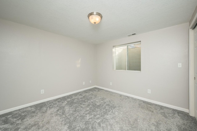 carpeted spare room with a textured ceiling