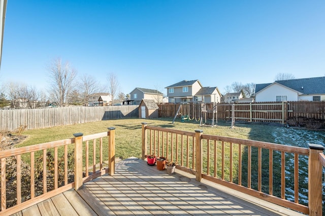 wooden terrace with a playground, a yard, and a storage shed