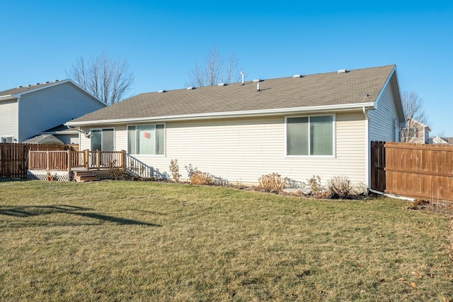 rear view of house featuring a wooden deck and a lawn