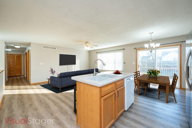kitchen with a sink, visible vents, light wood-style flooring, and dishwasher