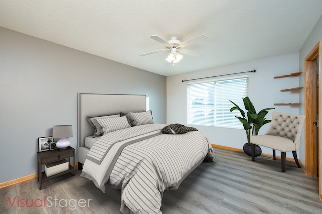 bedroom featuring baseboards, ceiling fan, and light wood-style flooring