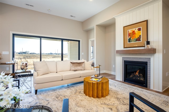 living room featuring a brick fireplace and hardwood / wood-style floors