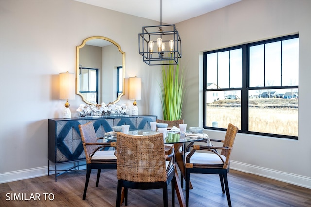 dining area featuring dark wood-type flooring, a chandelier, and a healthy amount of sunlight