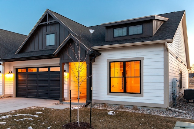 view of front of property featuring central AC unit and a garage