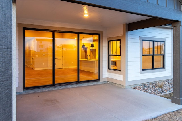 view of exterior entry with sink and a patio