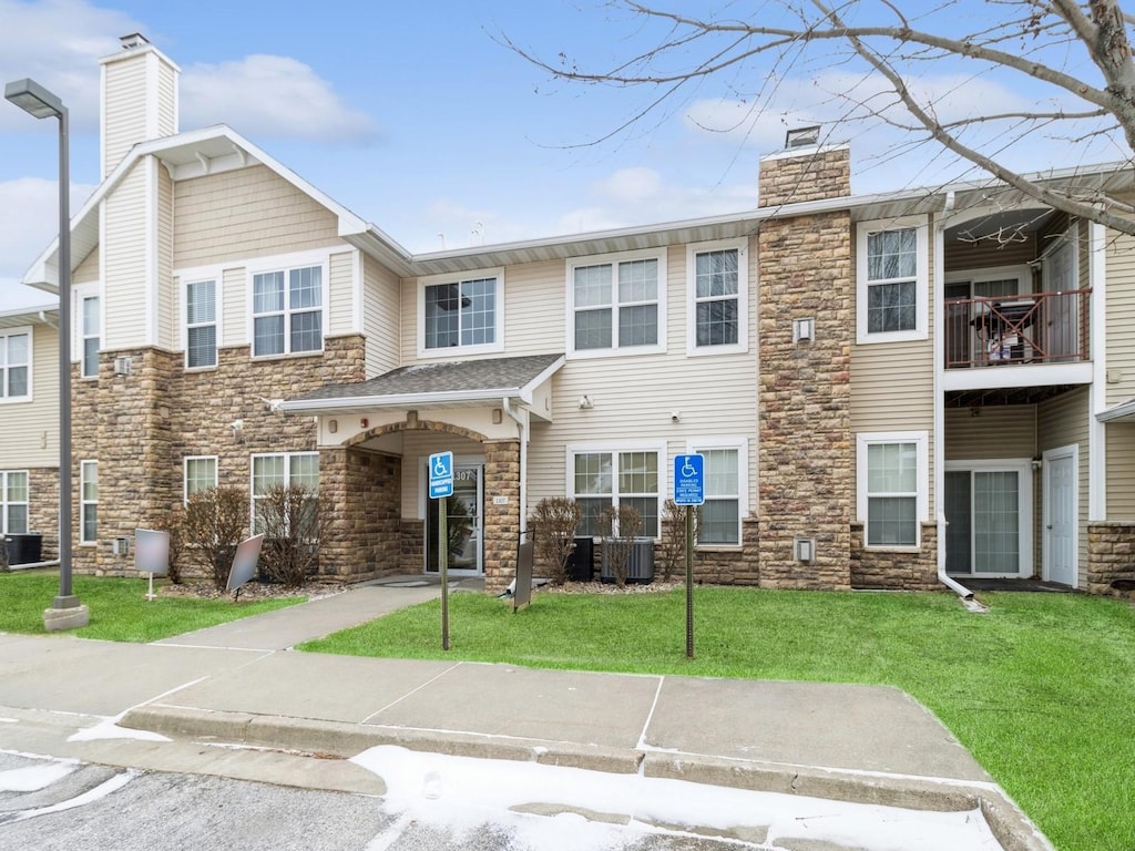 view of property featuring a front yard and central AC unit