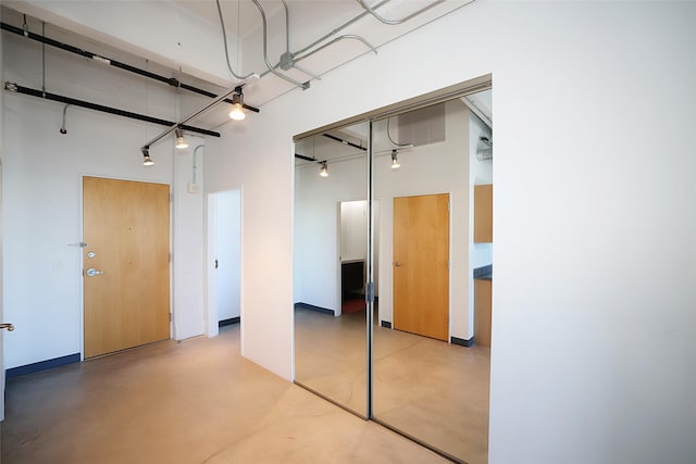 interior space with a closet, a towering ceiling, and concrete flooring