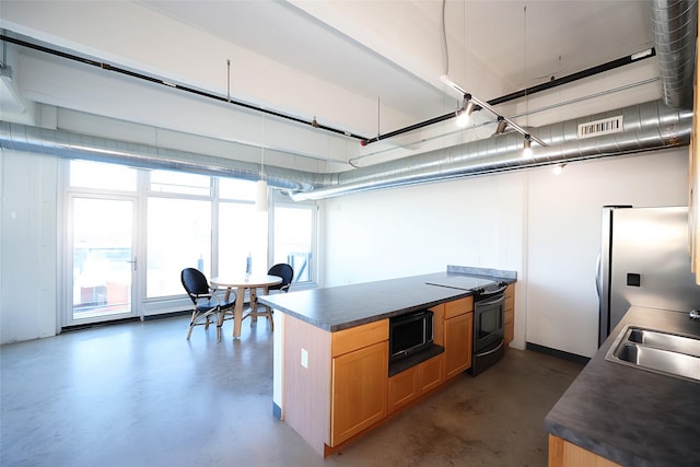 kitchen with electric stove, stainless steel fridge, and sink