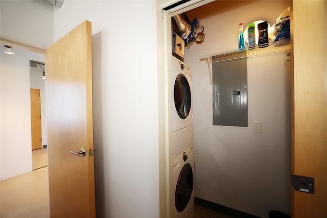 washroom with stacked washer and clothes dryer and electric panel