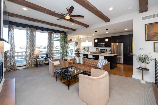 carpeted living room featuring ceiling fan and beamed ceiling