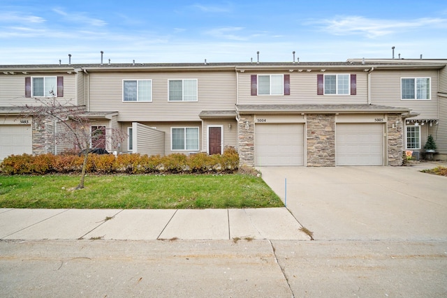 view of property featuring a front lawn and a garage