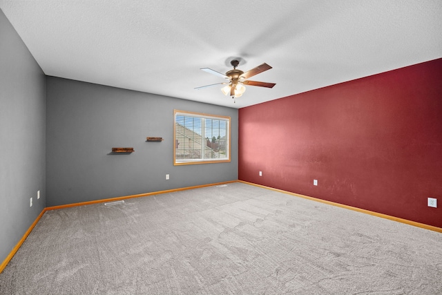 carpeted empty room featuring ceiling fan and a textured ceiling