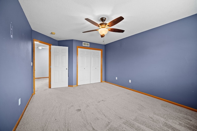 unfurnished bedroom featuring ceiling fan, a closet, and carpet floors