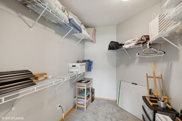 spacious closet featuring light colored carpet