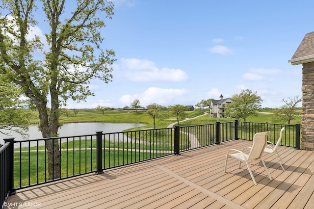 wooden terrace featuring a water view and a yard