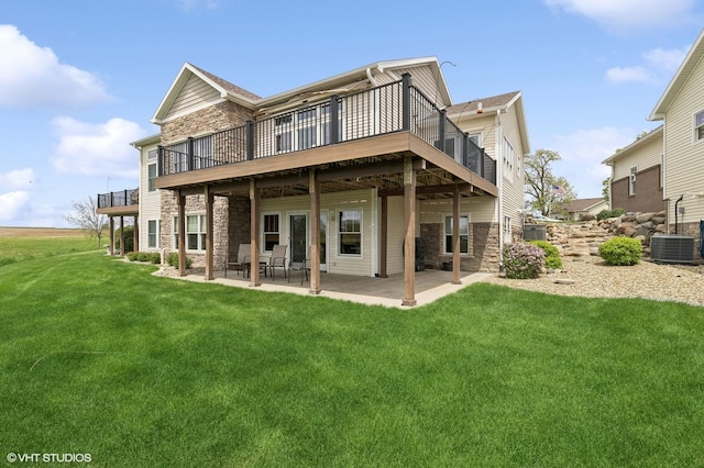 back of house with a patio area, a wooden deck, a lawn, and central air condition unit