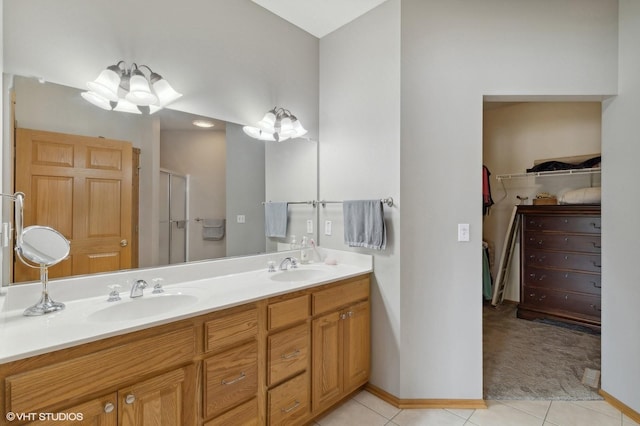 bathroom featuring tile patterned flooring, an enclosed shower, and vanity