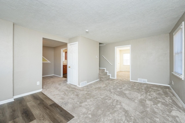 carpeted spare room with a textured ceiling