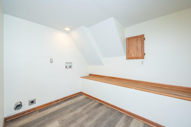 laundry room with a textured ceiling, hardwood / wood-style flooring, hookup for a washing machine, and hookup for an electric dryer