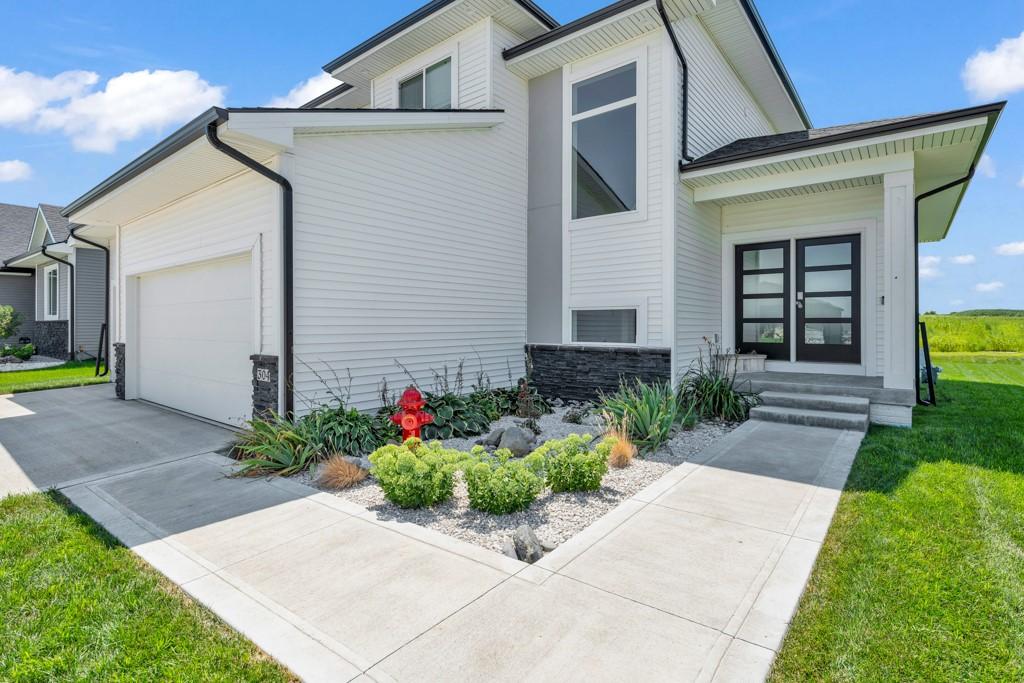 view of side of home featuring a garage and a lawn