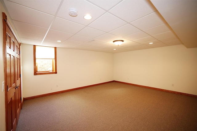 unfurnished room with carpet and a drop ceiling