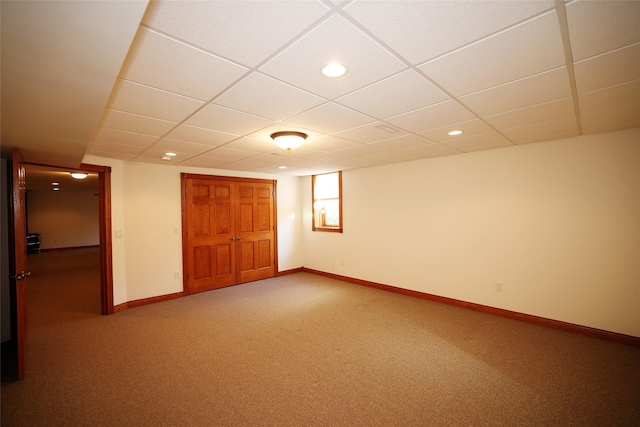 interior space featuring a paneled ceiling and carpet floors