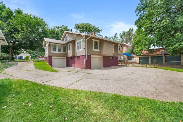 1001 42nd St, Des Moines, IA 50311 - view of front of property featuring an attached garage, a chimney, driveway, stucco siding, and brick siding