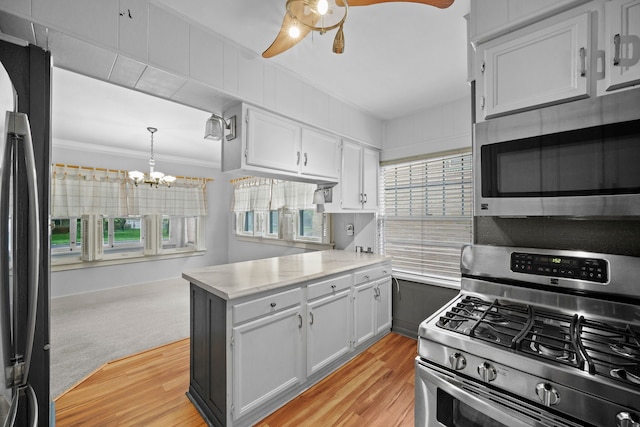 1001 42nd St, Des Moines, IA 50311 - kitchen with appliances with stainless steel finishes, a peninsula, a chandelier, light wood finished floors, and ornamental molding
