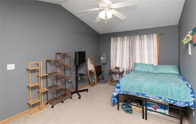 bedroom with ceiling fan, lofted ceiling, and carpet flooring