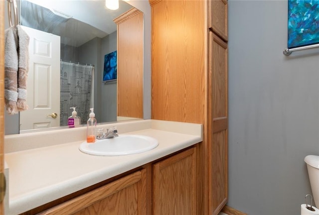 bathroom with toilet, vanity, and a shower with curtain