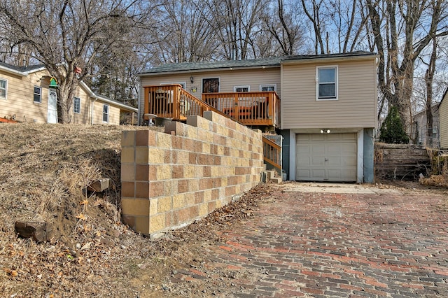 view of front of home featuring a garage and a wooden deck