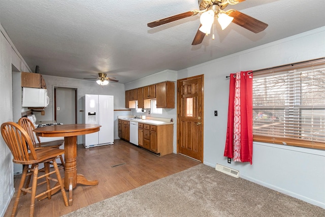 kitchen with white appliances, carpet, a textured ceiling, sink, and ornamental molding