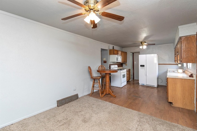 kitchen featuring white appliances, a textured ceiling, dark hardwood / wood-style floors, ornamental molding, and ceiling fan