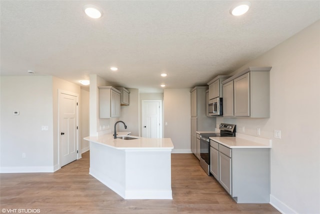 kitchen featuring appliances with stainless steel finishes, a sink, and gray cabinetry