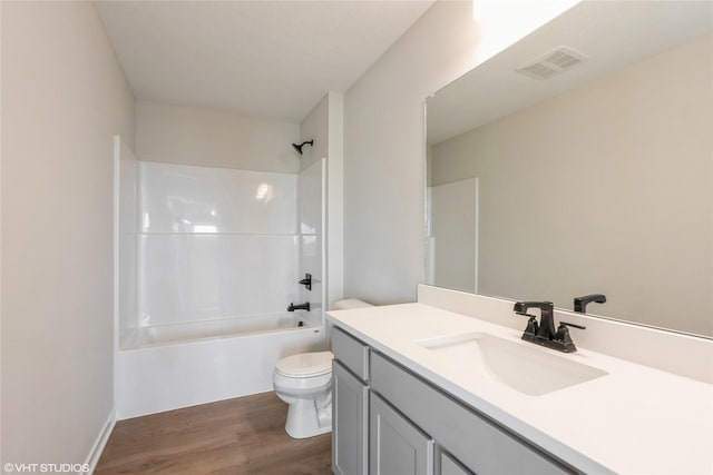 bathroom featuring toilet, visible vents, wood finished floors, washtub / shower combination, and vanity