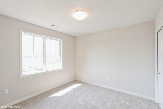 spare room featuring visible vents, baseboards, and carpet flooring