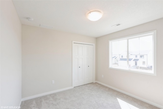 unfurnished bedroom featuring carpet floors, a closet, and baseboards