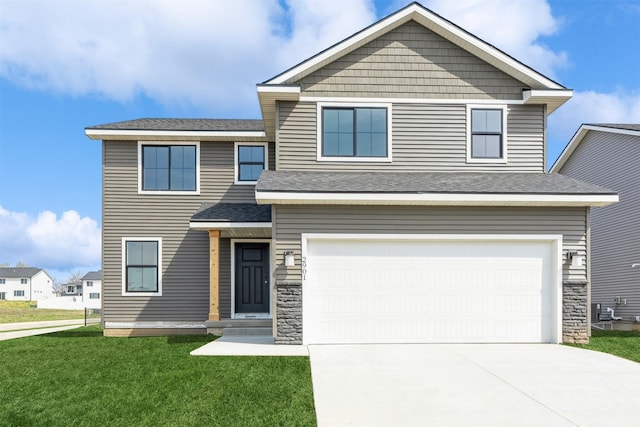 view of front of property with a front lawn, concrete driveway, an attached garage, stone siding, and roof with shingles