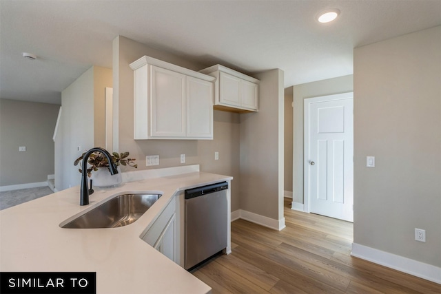 kitchen featuring stainless steel dishwasher, white cabinets, sink, and light hardwood / wood-style flooring