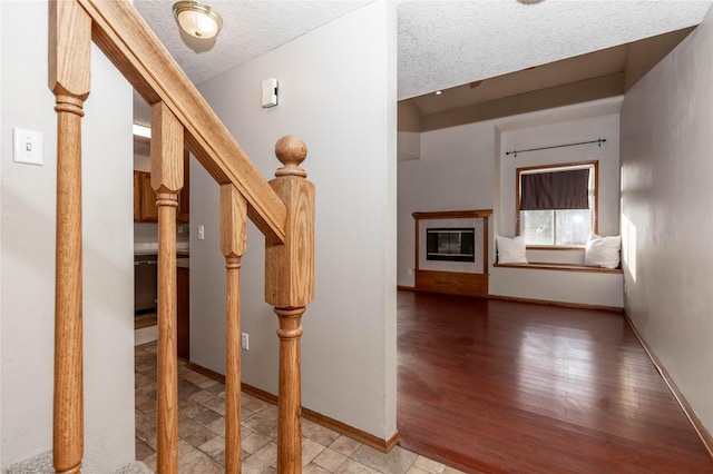 corridor featuring a textured ceiling and light hardwood / wood-style flooring