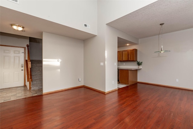 unfurnished living room featuring a textured ceiling and light hardwood / wood-style flooring