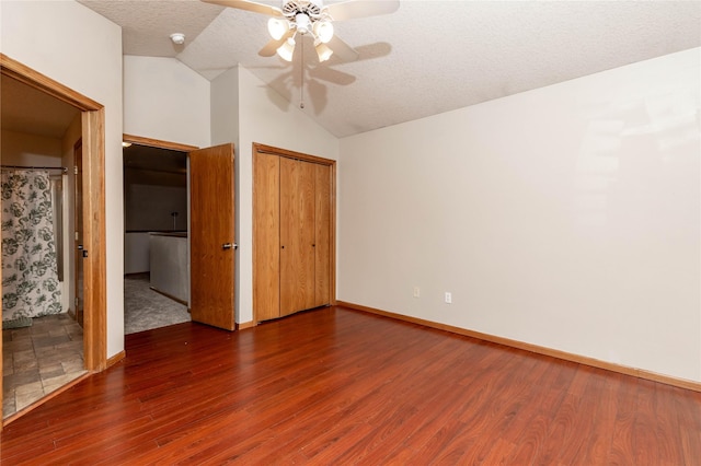 unfurnished bedroom with ceiling fan, a textured ceiling, dark hardwood / wood-style floors, and vaulted ceiling