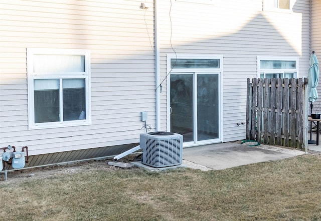 rear view of property featuring cooling unit, a yard, and a patio