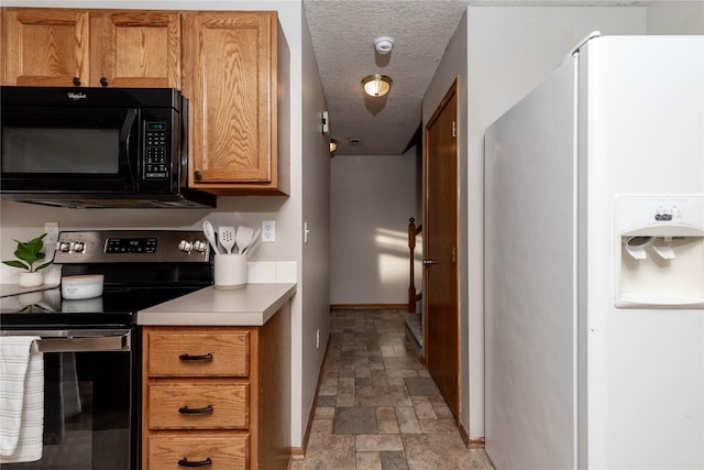 kitchen featuring a textured ceiling, white refrigerator with ice dispenser, and stainless steel electric range