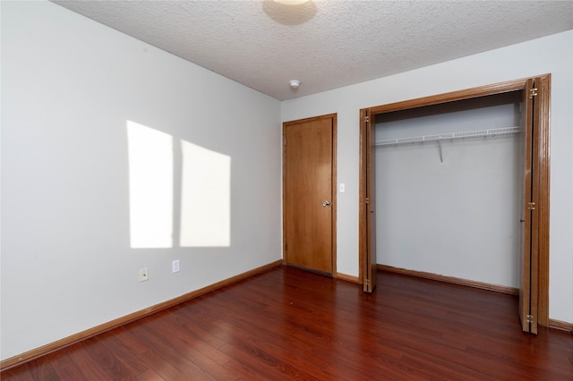 unfurnished bedroom featuring dark wood-type flooring and a textured ceiling