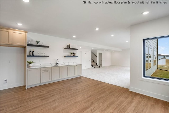 bar featuring sink and light hardwood / wood-style flooring