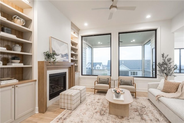 living room featuring light hardwood / wood-style flooring, built in features, and plenty of natural light