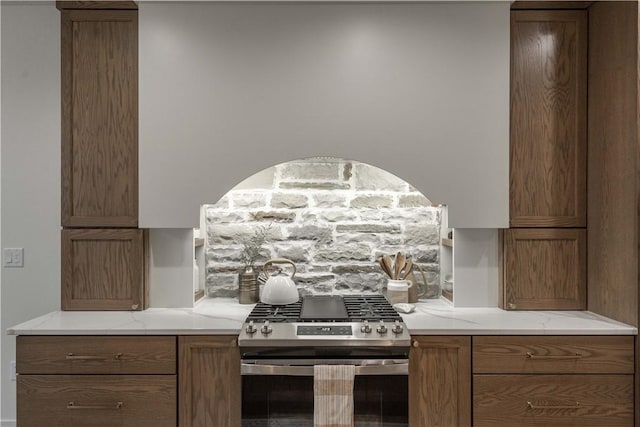 kitchen with light stone countertops and stainless steel gas range